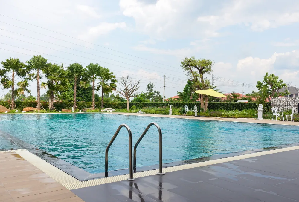 Grande piscine avec échelle et jardin tropical